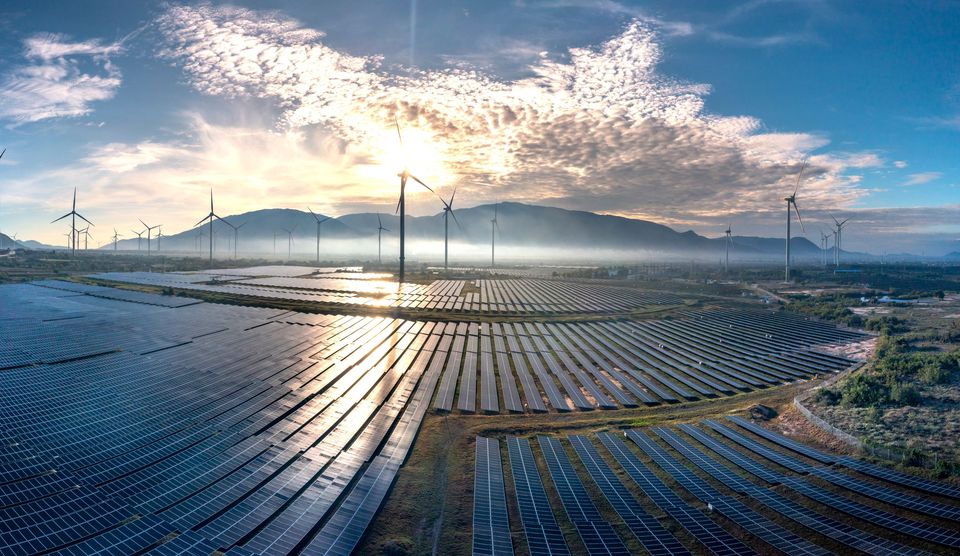 Wind turbines and a solar farm at sunrise