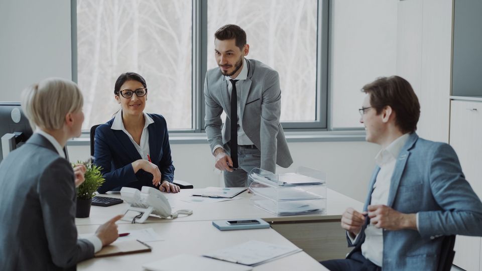 Colleagues discussing strategy around a meeting table