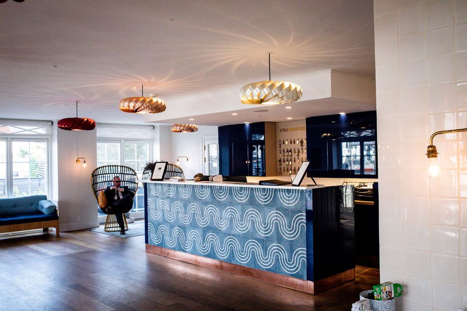 A modern hotel reception desk under designer lighting