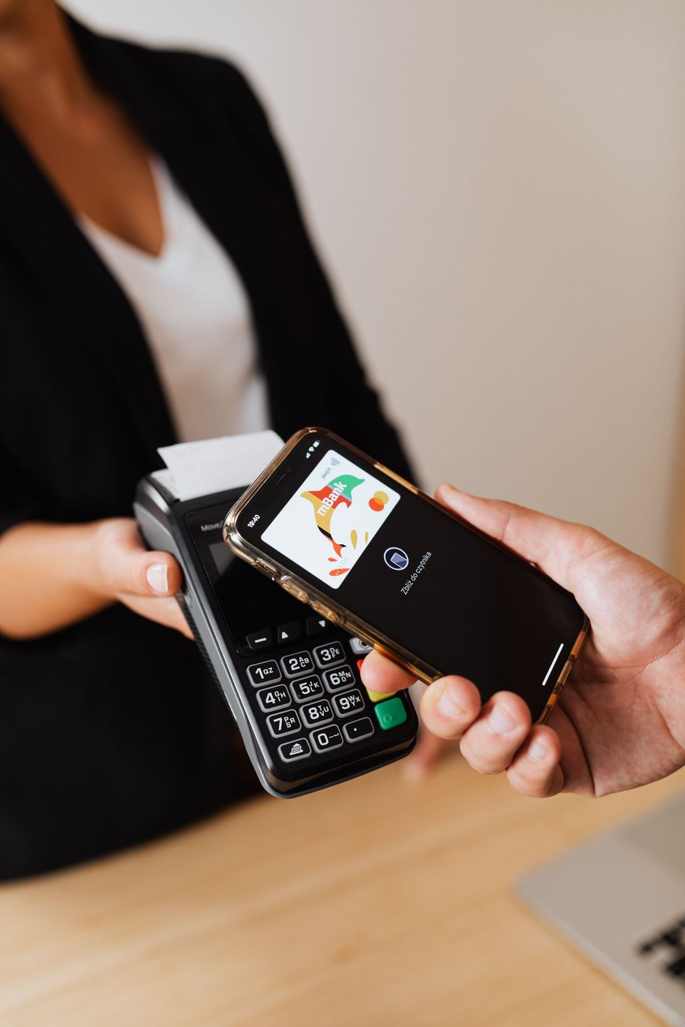 A customer paying contactlessly with a smartphone at a card terminal