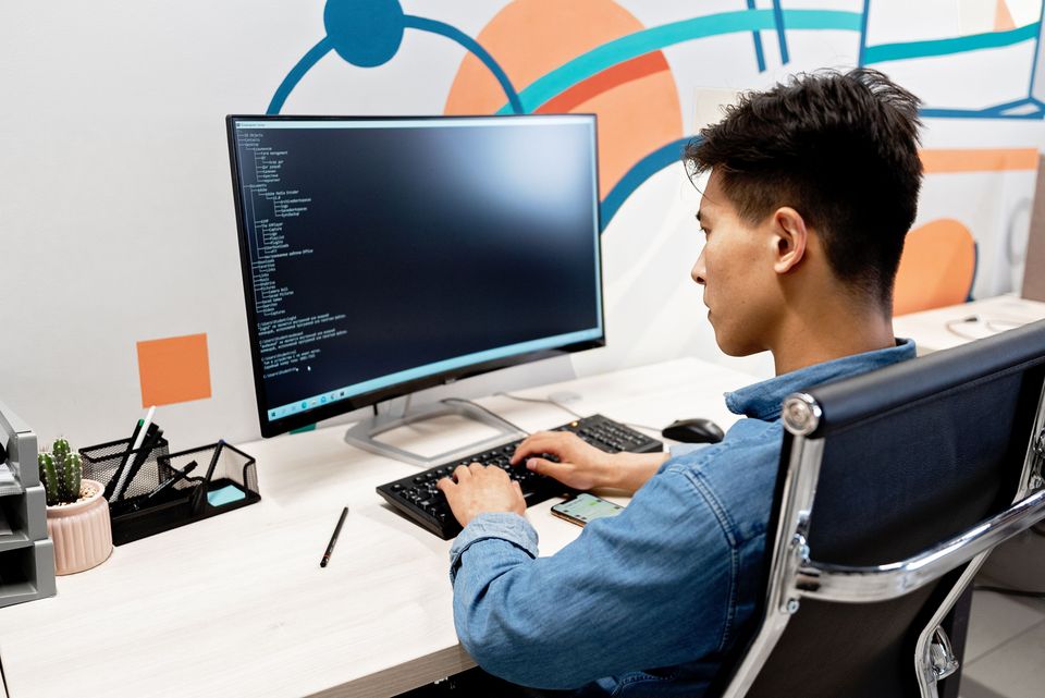 A developer writing code at a clean, well-lit desk